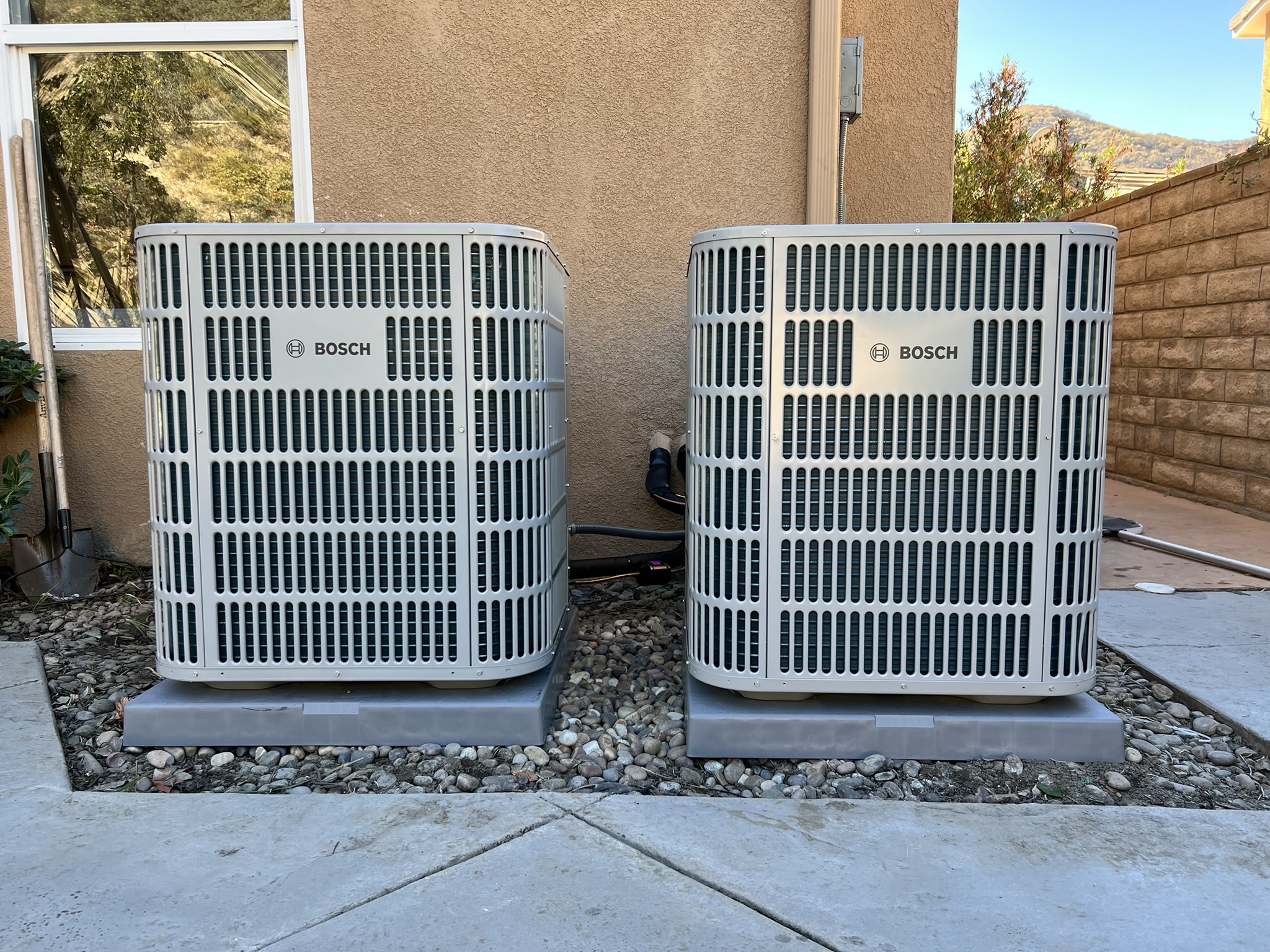 Two residential outdoor HVAC units installed side by side